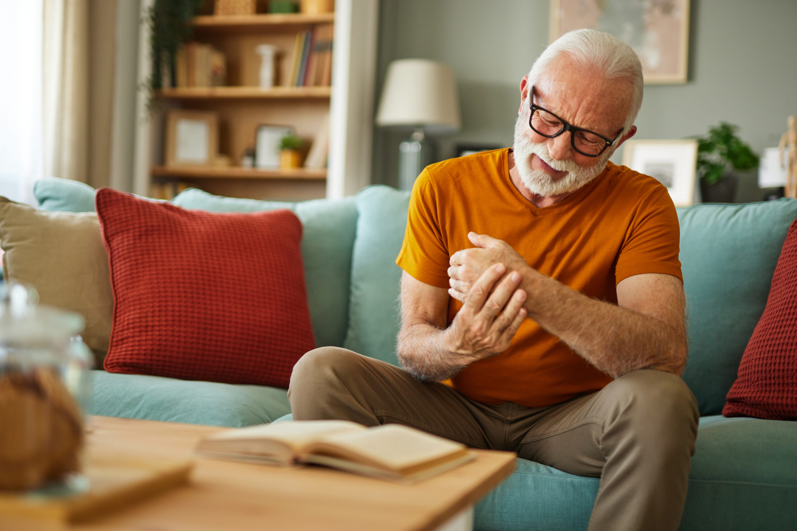 Elderly man suffering from his wrist joint pain at home