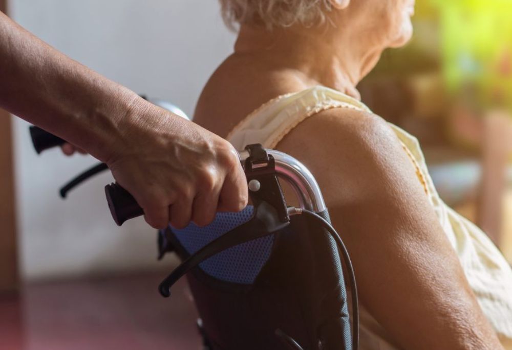 Senior in wheelchair nursing home care