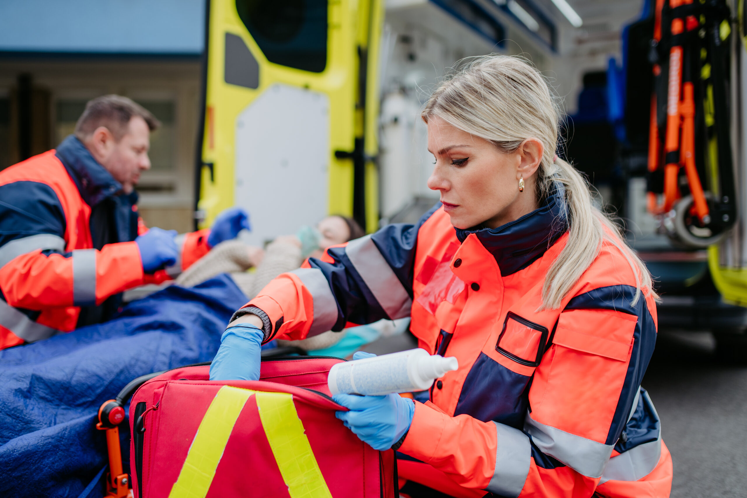 Emergency Medics Rescuers taking care of a patient, preparing her for transport.