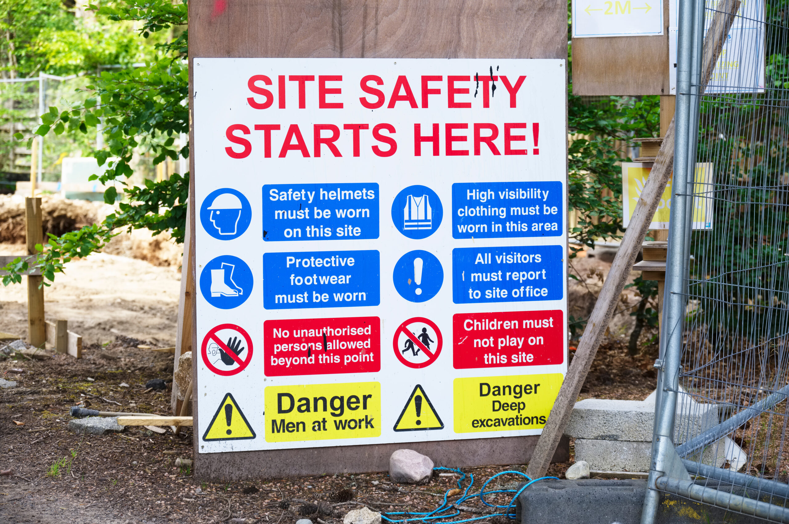 Construction site health and safety message rules sign board signage on fence boundary uk