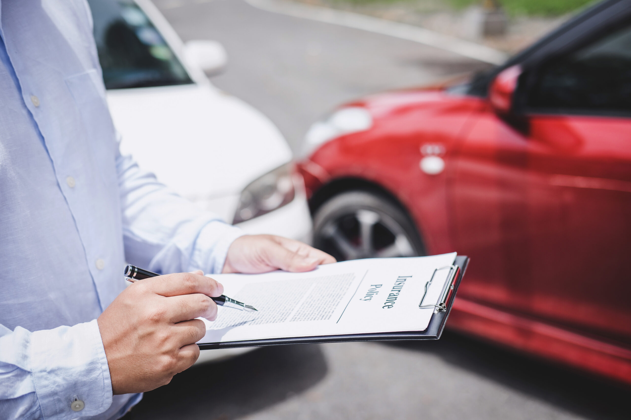 Traffic Accident and insurance concept, Insurance agent working on report form with car accident claim process.
