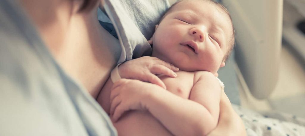 a baby sitting on a bed a baby sitting on a bed