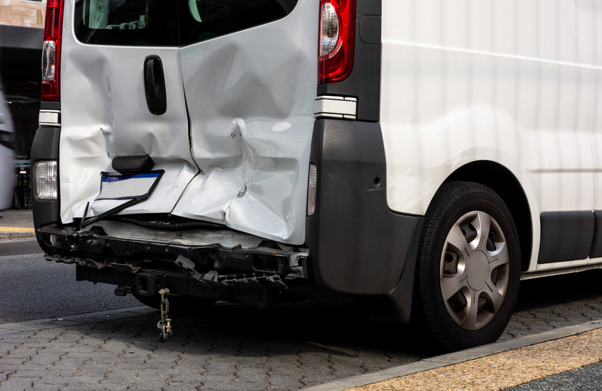White van damaged after a rear-end collision when the other driver was not paying attention and did not brake